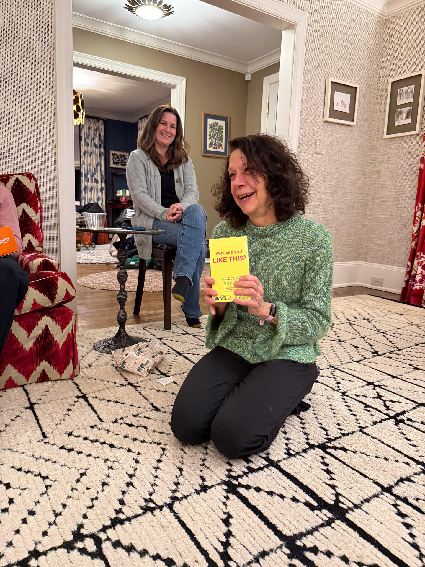 Bonnie holding her gift - a game called "Why are you like this?" - and laughing